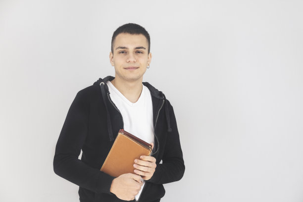 英俊的学生与书孤立在灰色的背景图片下载