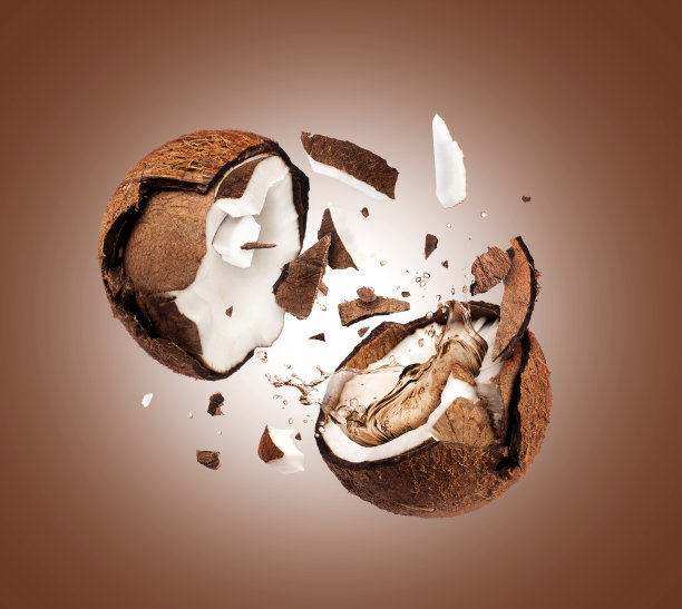 椰子在空中被劈成两半，背景为棕色图片下载