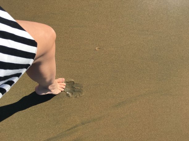 女孩的脚步在海沙上，脚印在沙上图片下载