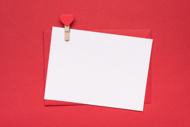 情人节快乐的概念。顶部头顶近距离平铺查看照片的红色信封白色空白纸卡和别针的形状孤立的红色背景图片下载