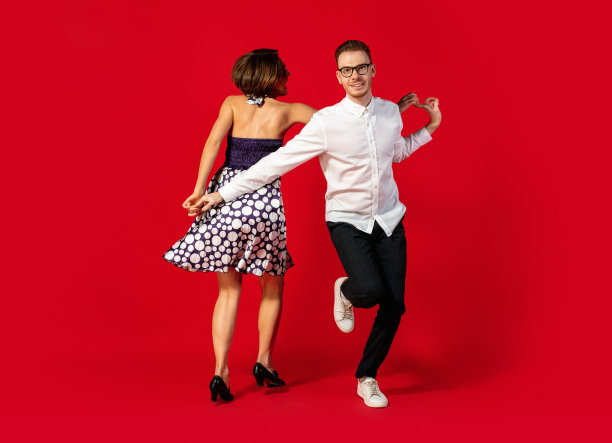 老式时尚的年轻夫妇在红色背景上跳舞图片下载