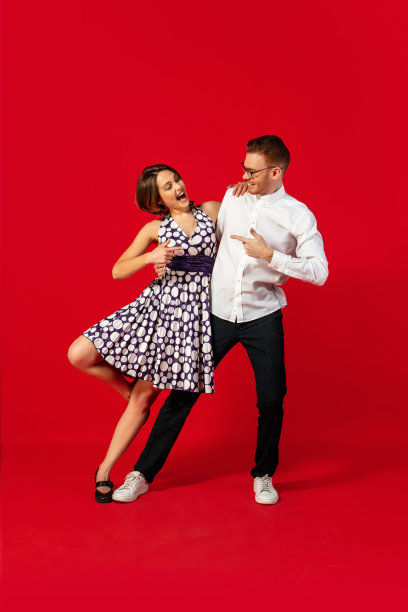 老式时尚的年轻夫妇在红色背景上跳舞图片下载