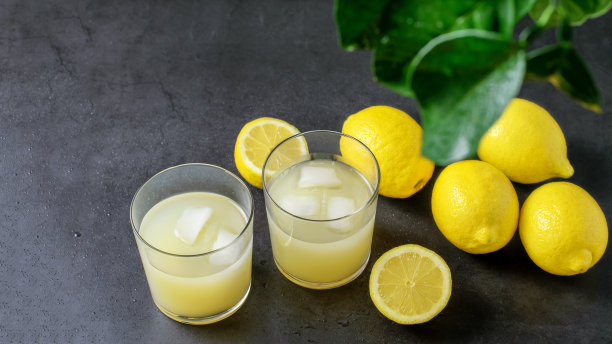 成熟的柠檬水果和新鲜的柠檬在灰色的背景。图片下载