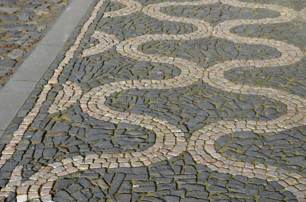 马赛克的小大理石立方体。人行道和广场由石地毯组成，地毯上有方格、圆点波纹图案。石质地毯粉，白色背景暗。玄武岩粗铺在树下空间。阈值图片下载