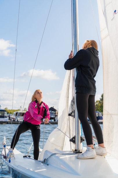 比赛前，两个可爱的小女孩在帆船上装备她们的帆船图片下载
