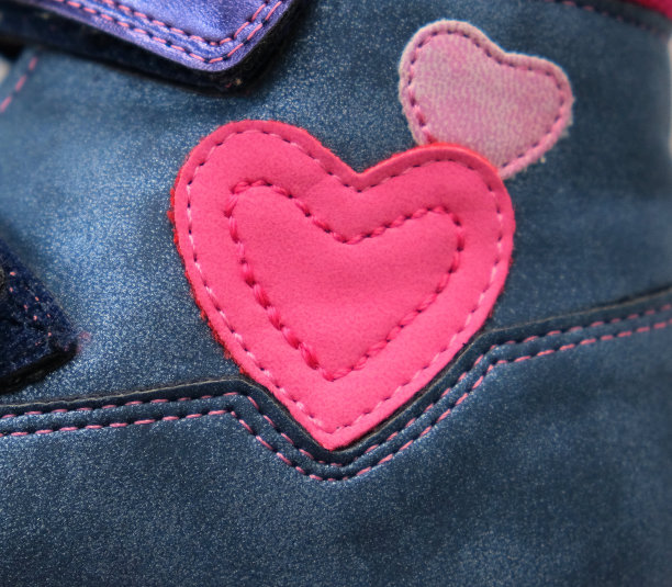 宏观细节皮革补丁，心形配件在儿童鞋上图片下载