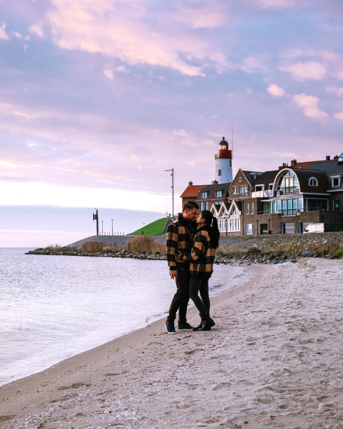 荷兰厄克弗莱弗兰，一对男女在荷兰厄克的小渔村港口观看日落图片下载