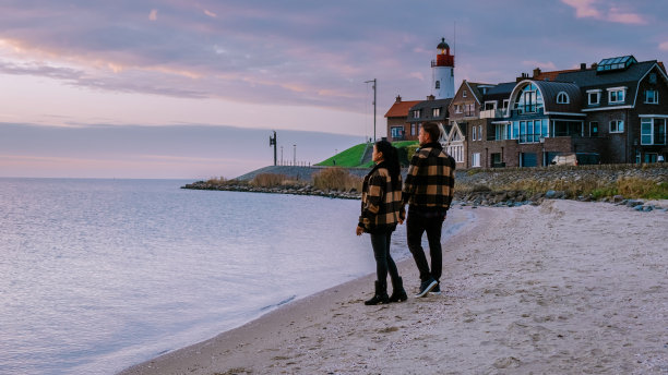 荷兰厄克弗莱弗兰，一对男女在荷兰厄克的小渔村港口观看日落图片下载