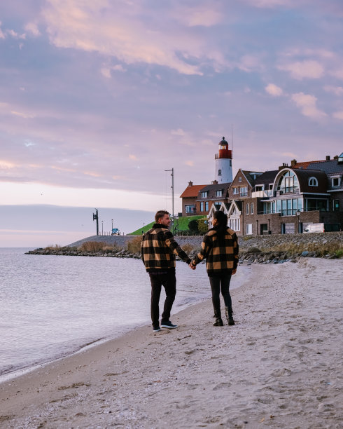 荷兰厄克弗莱弗兰，一对男女在荷兰厄克的小渔村港口观看日落图片下载