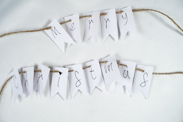 用棕色线和白色背景的白色床单上的字母写着圣诞快乐的短信图片下载