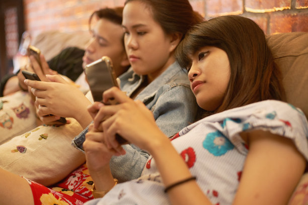 社交聚会，但朋友忙于自己的智能手机图片下载
