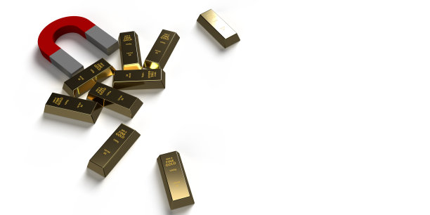 金锭被白色背景上的红色磁铁吸引图片下载