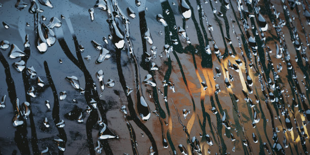 雨点落在雾蒙蒙的玻璃飞机上，背景模糊图片下载