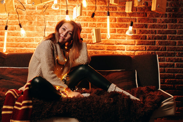 坐在沙发上的可爱女孩。图片下载