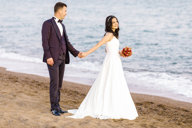 新婚夫妇在海滩上享受图片下载