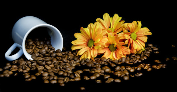 从白色的杯子里倒出咖啡豆图片下载