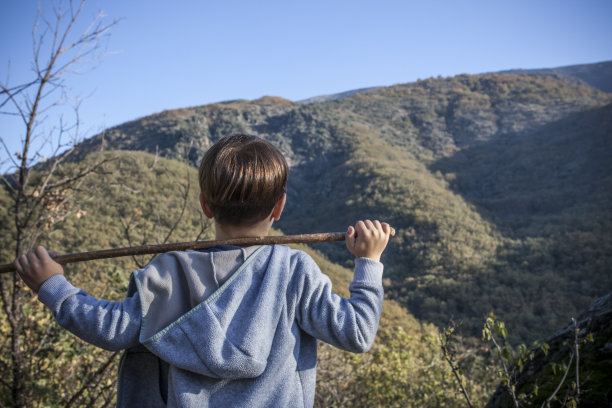 西班牙埃斯特雷马杜拉，一名小男孩在自然保护区观察瀑布图片下载