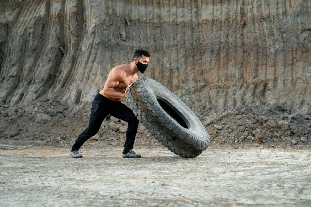 活跃的家伙与肌肉的身体拉大轮胎图片下载