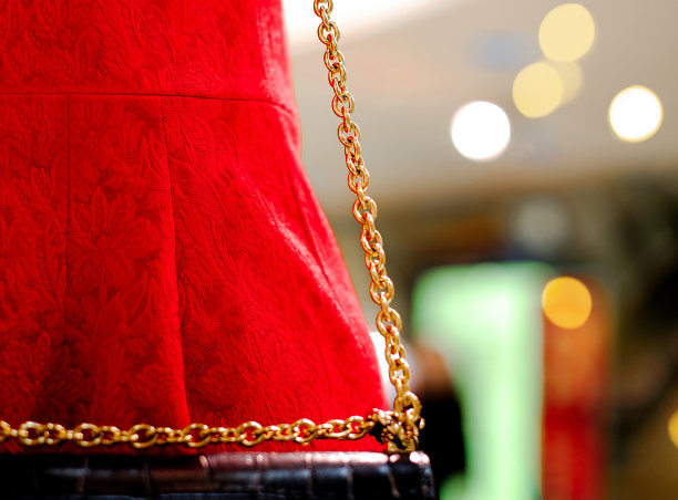 手提包的细节。时尚细节的大红色女装和黑色手包的金色链带，宏观照片，时尚风格，美丽图片下载