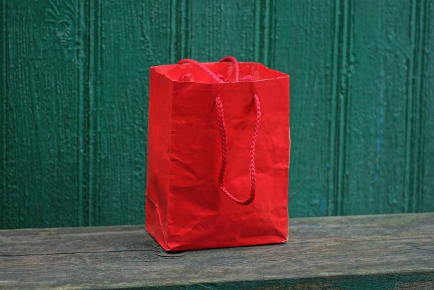 桌子上放着一个红色纸袋图片下载