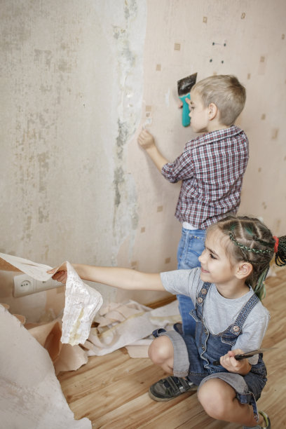 父亲和孩子一起修补房间，一起拆墙纸图片下载