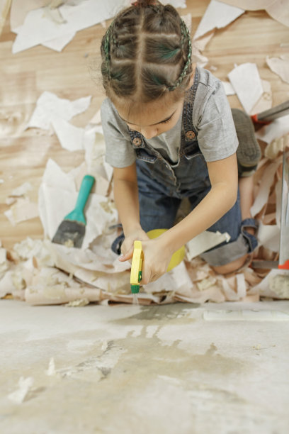 父亲和孩子一起修补房间，一起拆墙纸图片下载