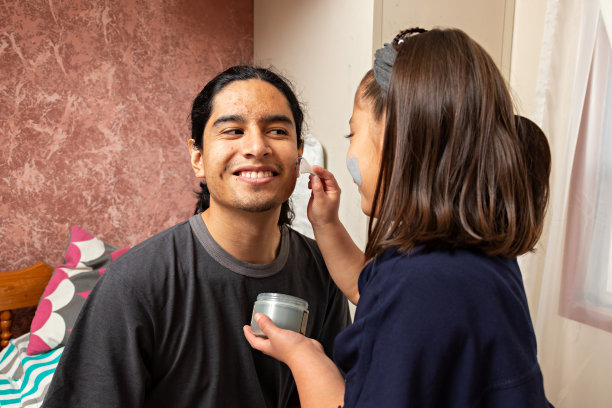 小伙子和姑娘坐在床上谈笑风生，一边抹面霜，一边在家里泡温泉图片下载