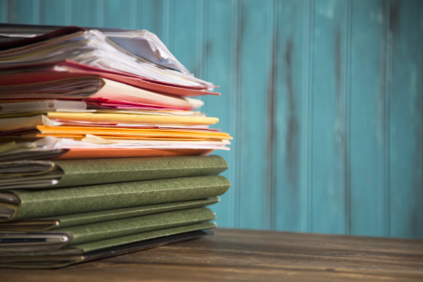 在木质的桌面桌上堆放文件夹和文件。图片下载