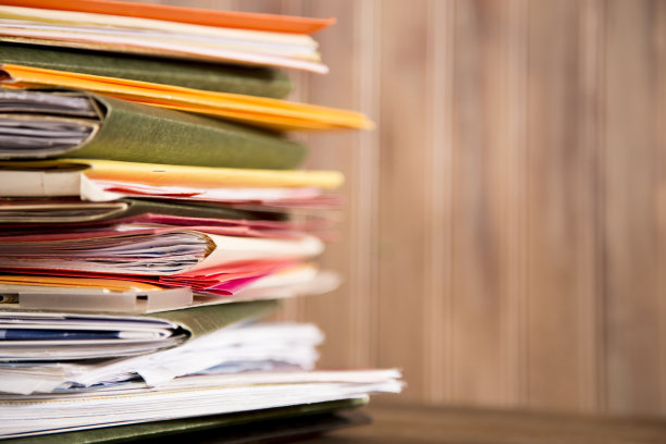 在木质的桌面桌上堆放文件夹和文件。图片下载