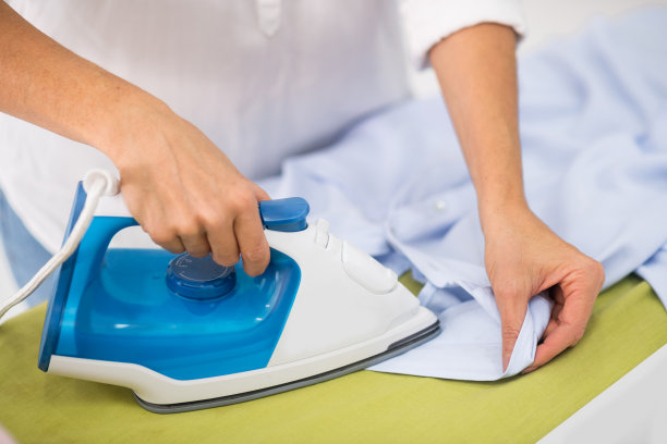 女性熨烫衣服的手的特写照片图片下载