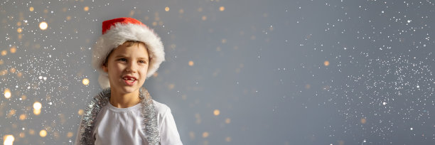 穿白t恤戴圣诞帽的男孩。图片下载