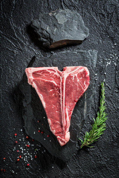 新鲜的红t骨牛排，加盐，胡椒和迷迭香图片下载