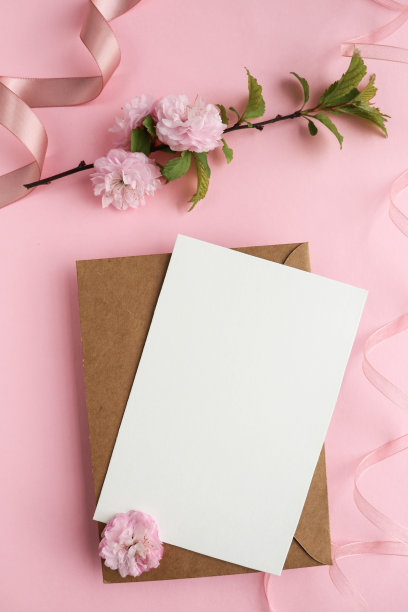 春季明信片的模型。盛开的樱花枝在粉红色的背景和一个信封图片下载
