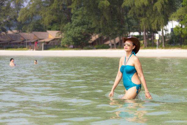 穿着蓝色泳衣的女人在海滩的海水里很漂亮图片下载