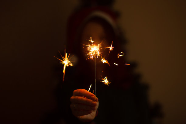 圣诞节或新年派对上拿着烟花的女人。图片下载