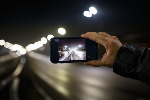 一名男子在晚上用智能手机拍下了一条大马路的照片图片下载