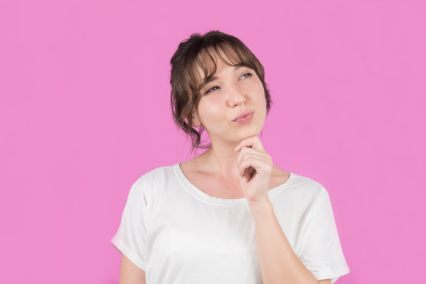 女孩孤立的粉红色背景思考一个想法。图片下载