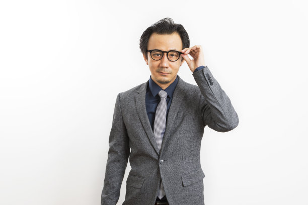 成功的亚洲商人手触摸眼镜在白色的背景。图片下载