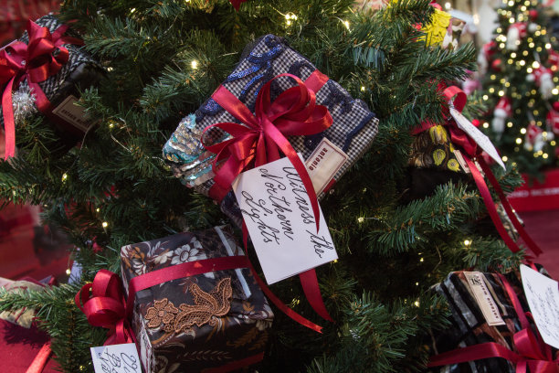一棵装饰过的圣诞树的特写，上面有礼物盒和新年旅行的愿望。圣诞节的背景。水平方向图片下载