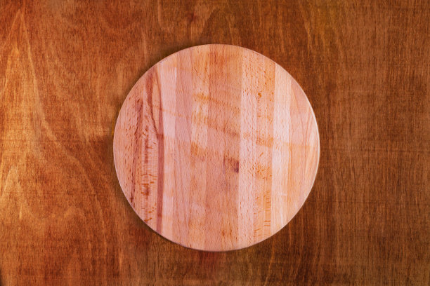 圆形的披萨砧板放在老旧的木桌上，俯视图图片下载