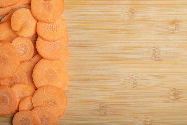 一堆切好的胡萝卜在一个木制的竹制砧板上的特写图片下载