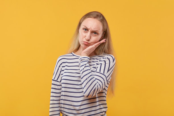 一个悲伤的年轻美丽的女人看着相机的肖像。图片下载