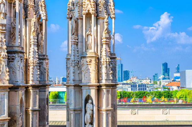 著名的米兰大教堂屋顶上的白色大理石雕像和米兰市中心的顶部鸟瞰图图片下载