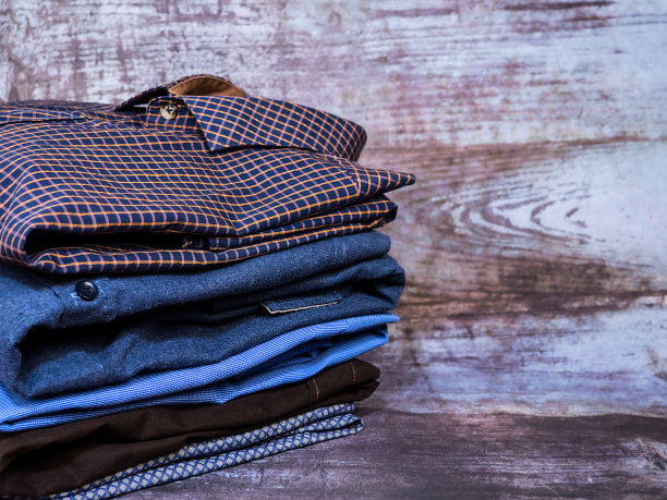 桌子上放着不同颜色的男衬衫。背景和纹理。图片下载