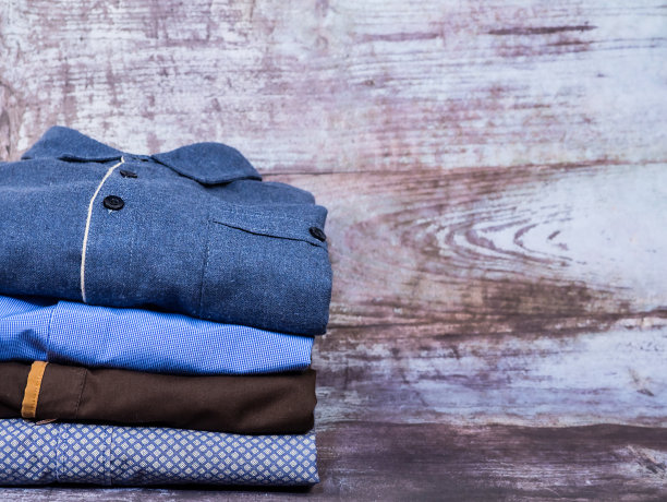 桌子上放着不同颜色的男衬衫。背景和纹理。图片下载