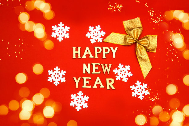 题词新年快乐木制字母在红色的背景与雪花和弓，bokeh。新年贺卡、横幅图片下载