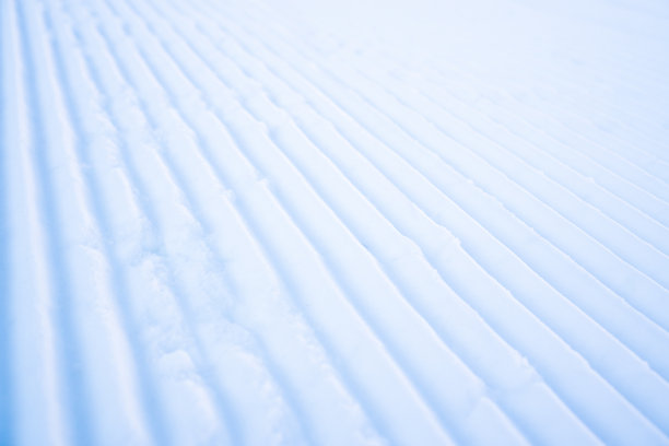 在雪猫之后整理雪。天鹅绒质地滑雪。山上滑雪道上的新雪道图片下载