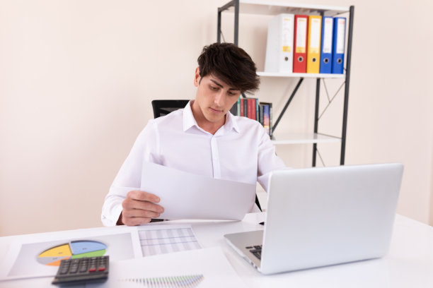 紧张的商人看着图形并在电脑上做笔记图片下载