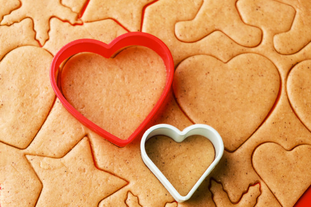 情人节用来做心形饼干的面团。自制的糕点。红色和绿色塑料烘烤模具。图片下载