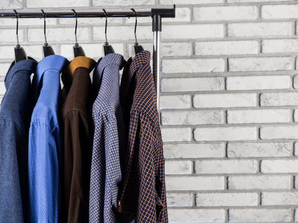 不同颜色的衬衫正挂在衣架上。男人的衣柜。风格和时尚。背景和纹理。图片下载